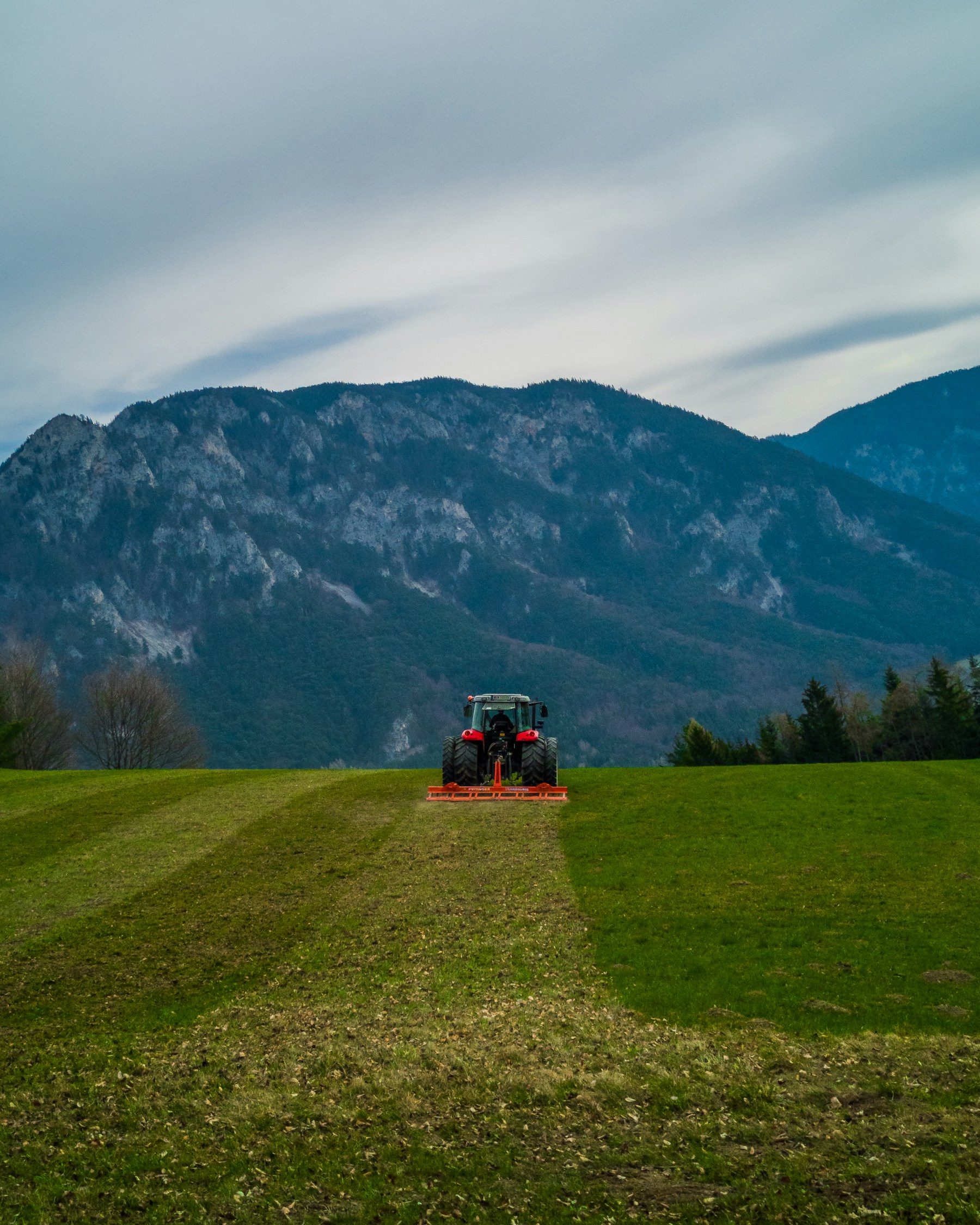 Landwirtschaftliche Fläche mit Traktor als Beispiel für Grund, der verkauft oder verpachtet werden kann